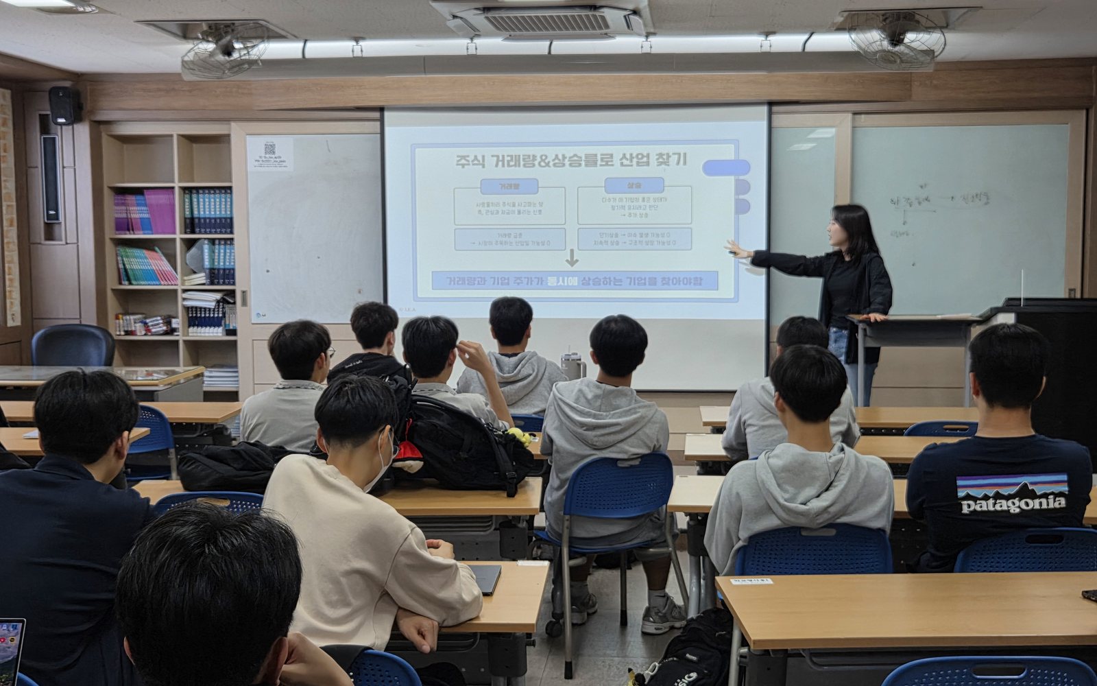 인천 남동고 교실에서 대학생 멘토가 Plain 슬라이드로 경제교실 수업을 진행하는 모습